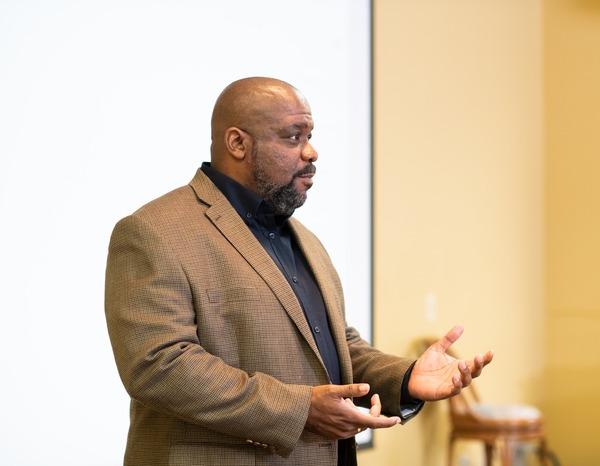 A male business professor teaching in front of a class.