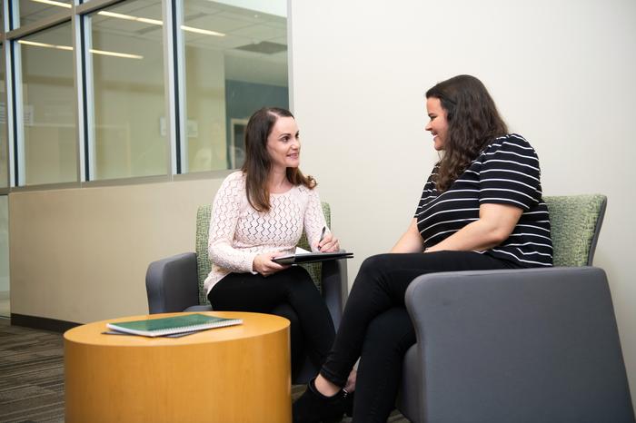 A female student sitting and speaking with a counseling professor.